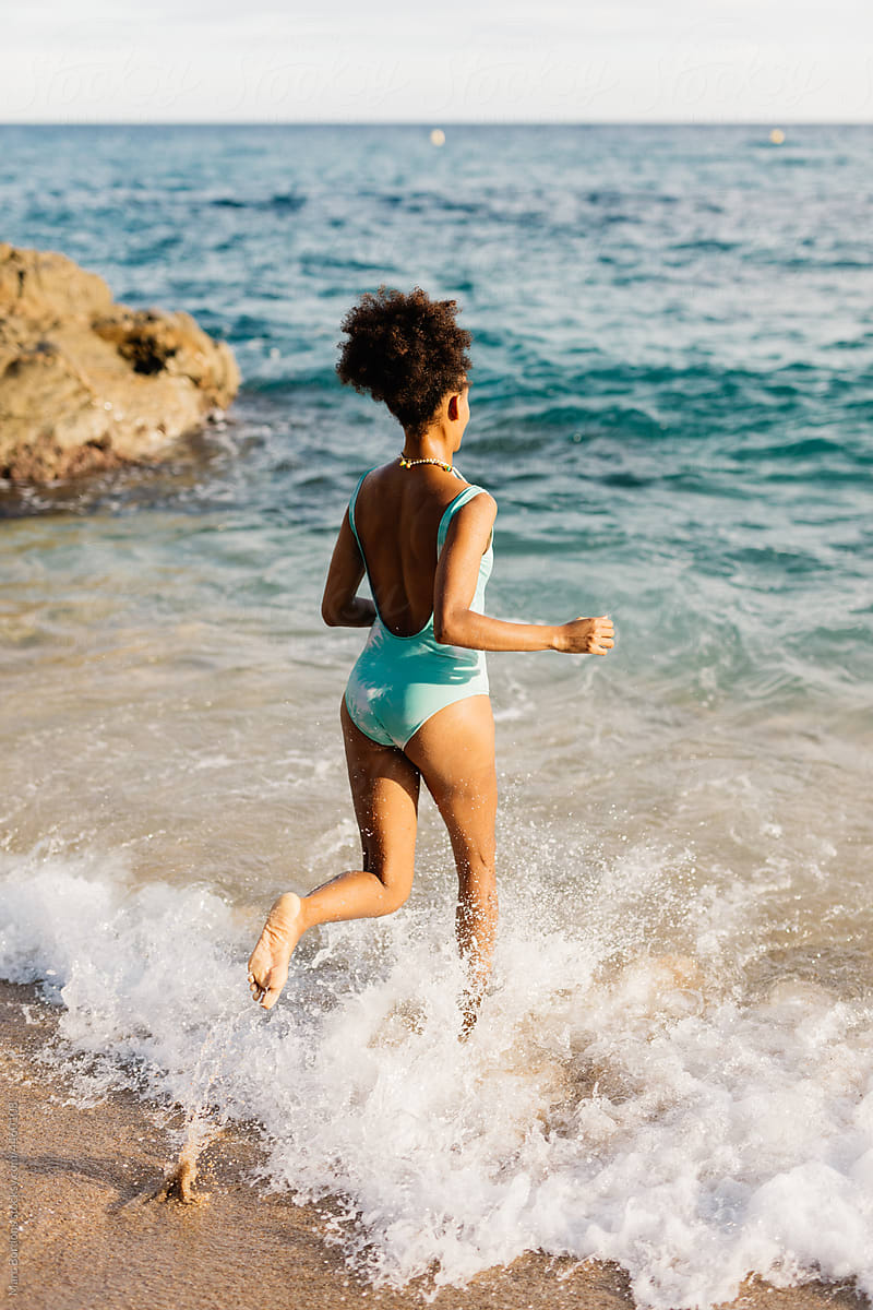 a woman entering the sea to swim