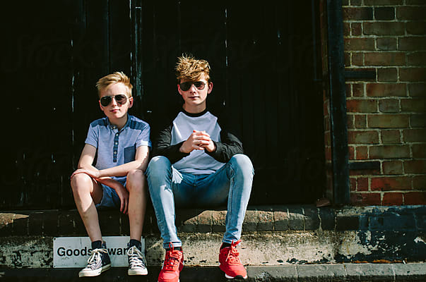 2 Teenage Boys In Shades In Front Of A Wall With Graffiti. by
