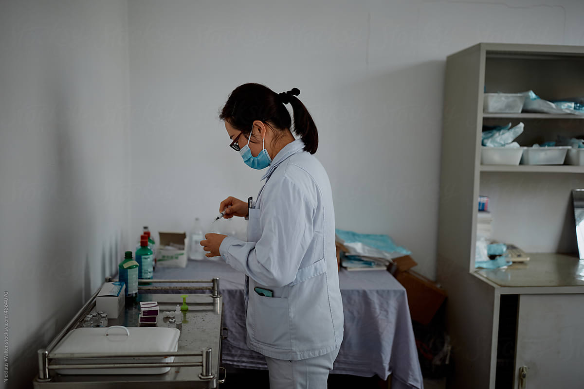 Female Chinese doctor prepares medicine at a hospital