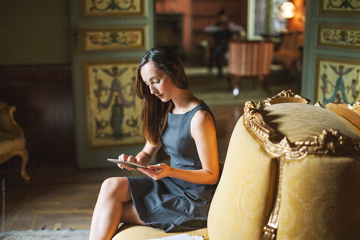 Young businesswoman working with digital tablet at beautiful baroque room.