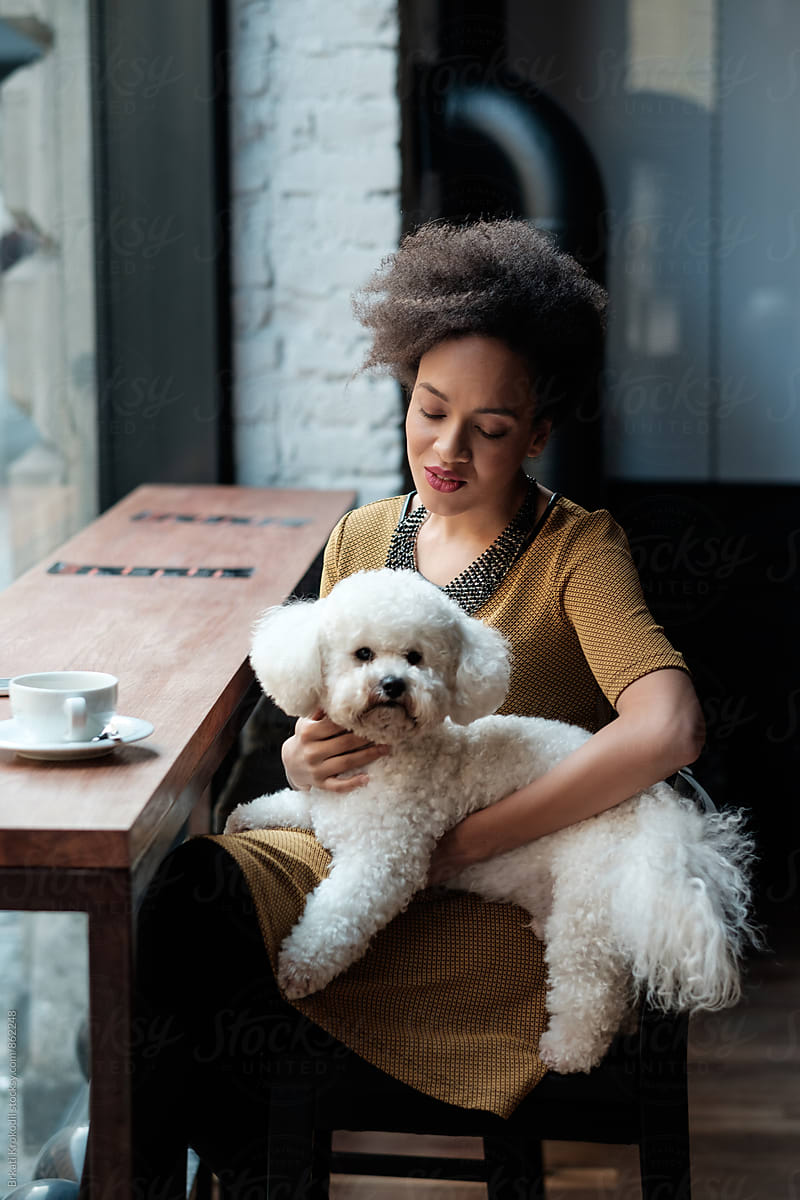 Black Woman Sitting At The Cafe With Her Dog