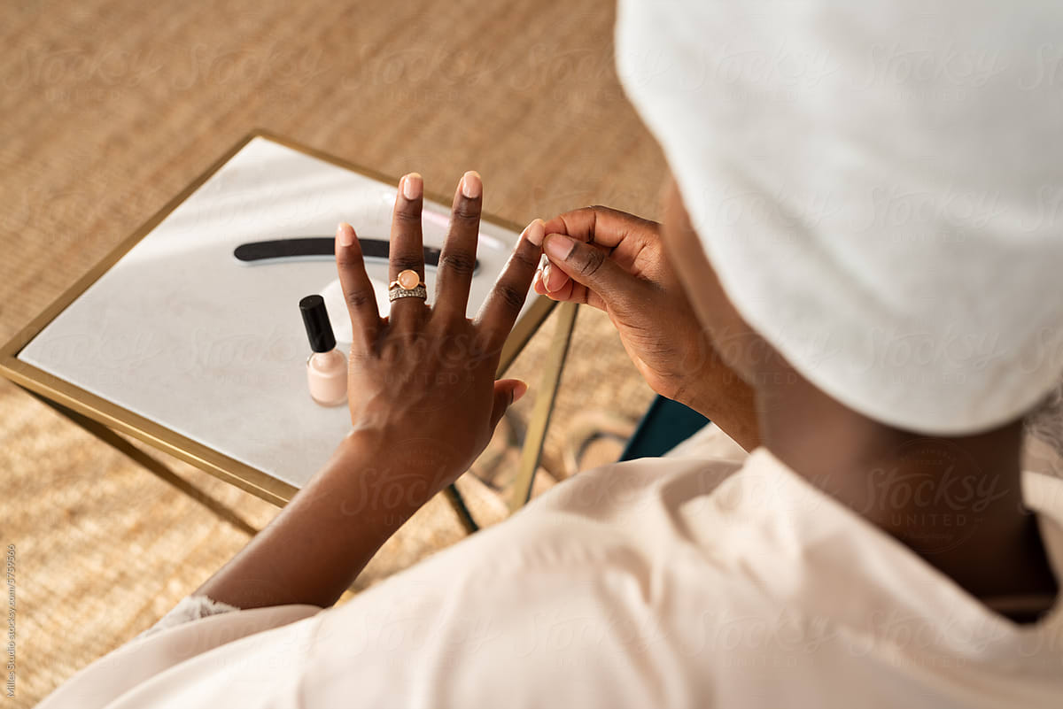 Crop black woman doing manicure at home