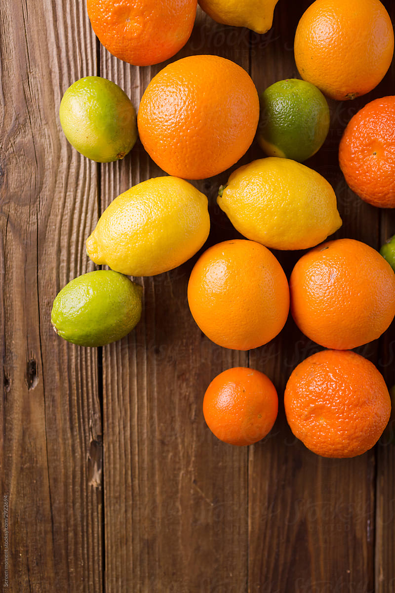 Orange and lemon, lime on a wooden background.