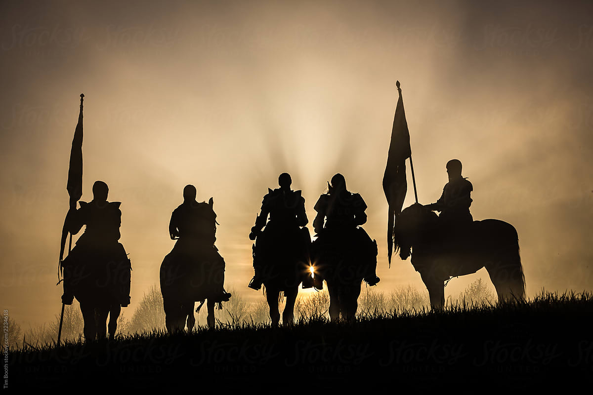 A group of medieval knights silhouetted against the sunset.
