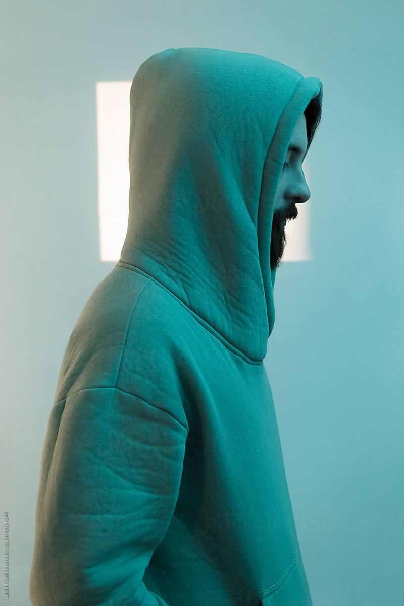 Profile of a hooded man in a green sweatshirt