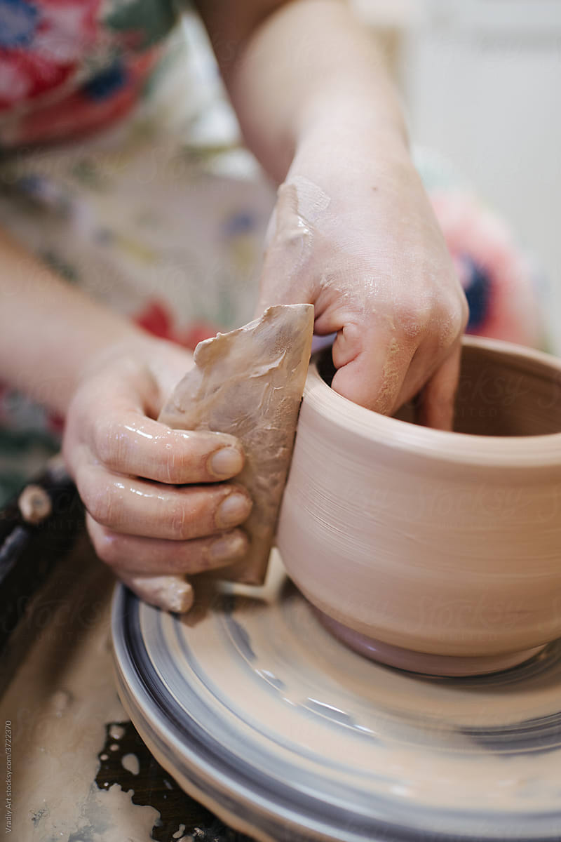 Potter using tool while doing pottery