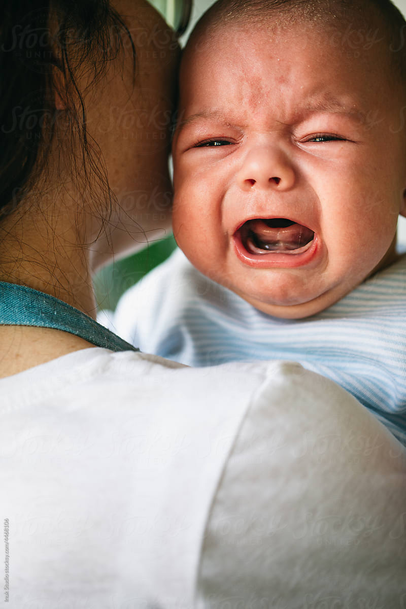 Parent comforting screaming annoyed newborn baby