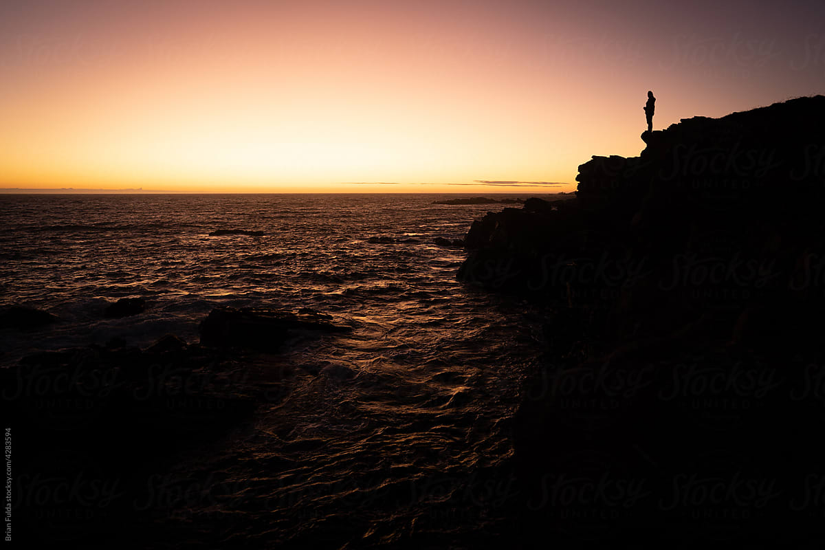 Silhouette of a Person on the Coast at Sunset