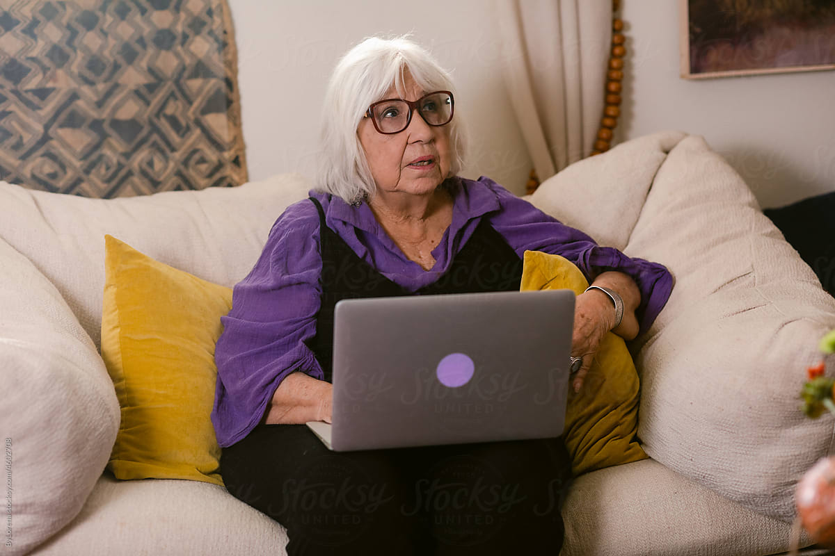 Modern granny with laptop at living room