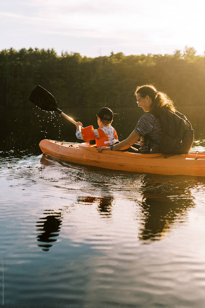 little boy in a kayak with his grandmother on a lake
