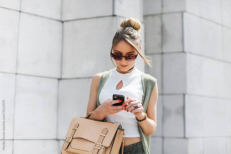 Young busy woman using her smart phone