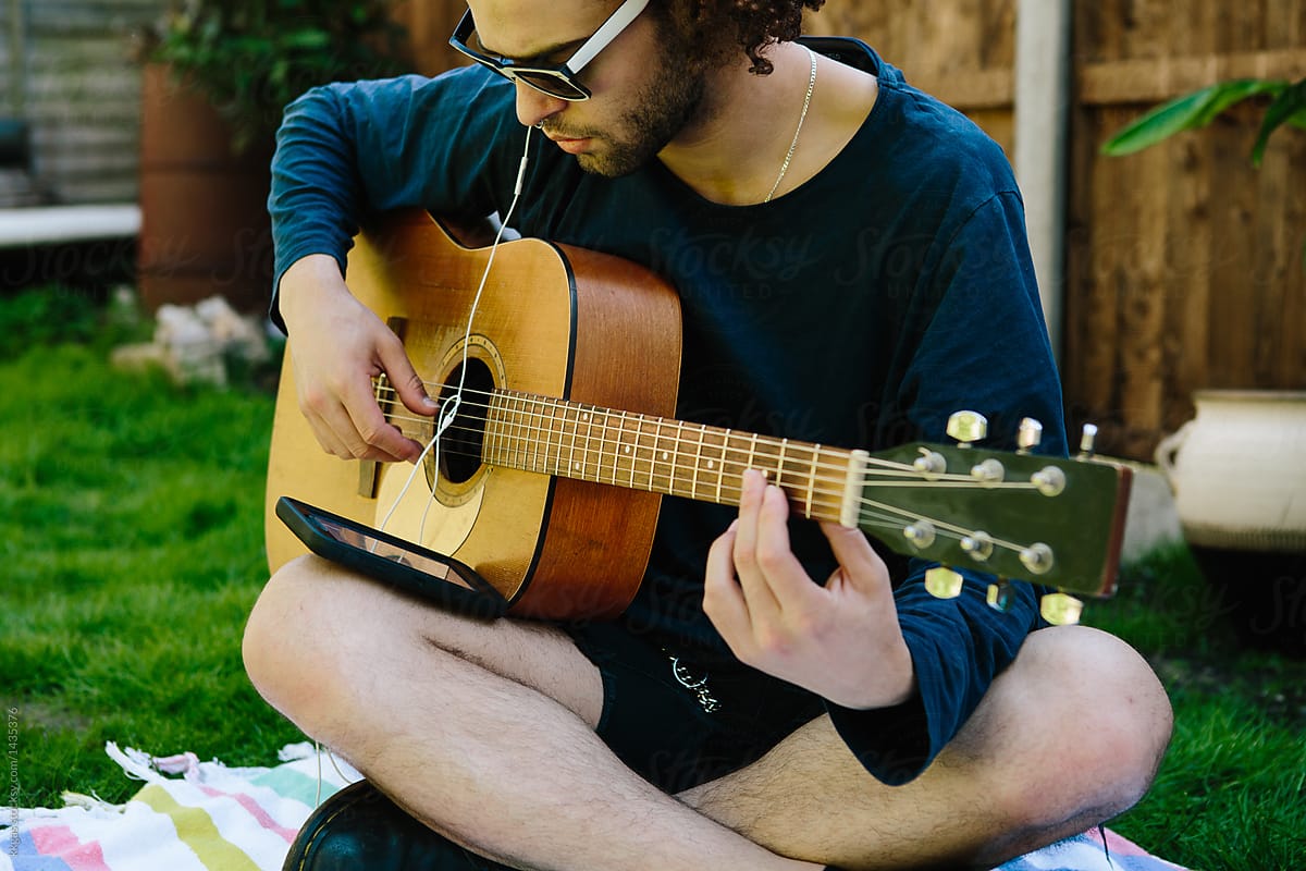Man playing acoustic guitar learning guitar tablature