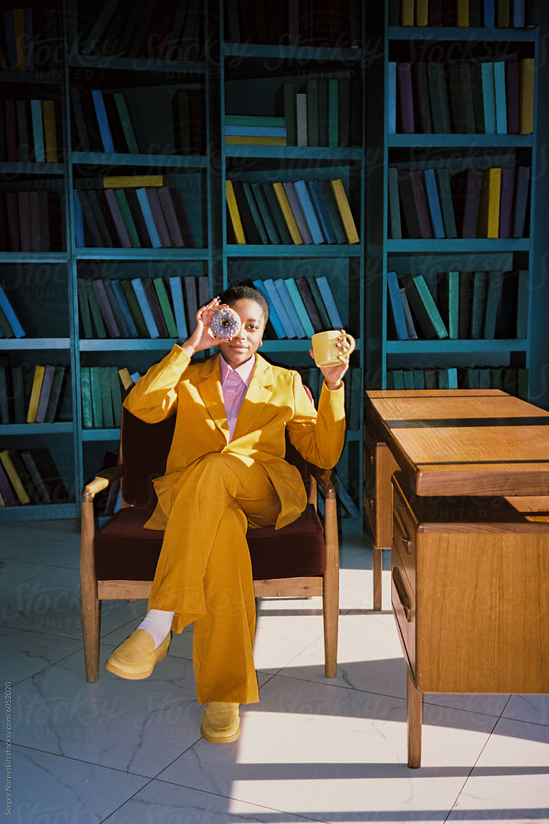 Woman in yellow suit against shelf with books
