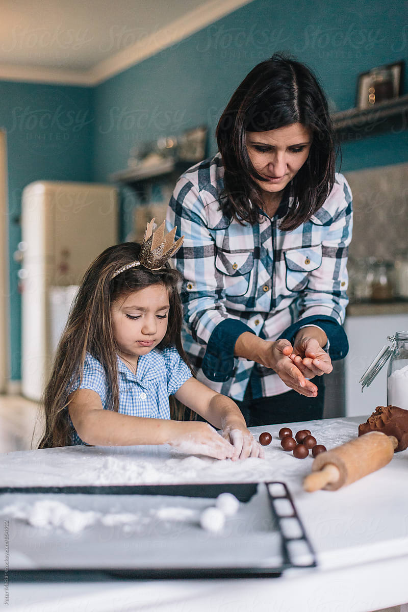 Mother and daughter baking a cakes with Chocolate Crinkles and sweet cakes