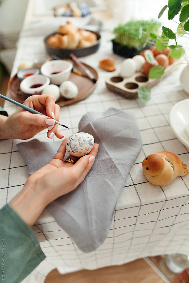 An unrecognizable woman paints eggs with natural dyes.