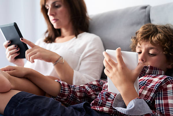 Barefoot Kids On Sofa Gaming» del colaborador de Stocksy «Guille Faingold»  - Stocksy