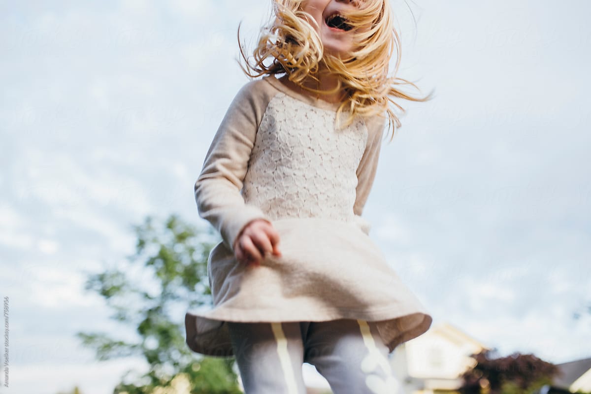 Crop Shot Of Little Girl Joyfully Jumping outside