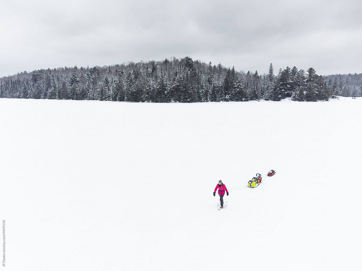 Pulling Winter Camping Gear Sled Across Frozen Lake