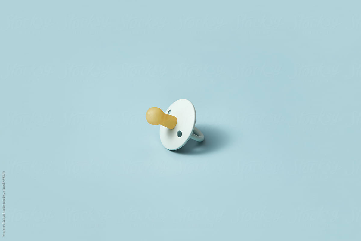 One baby pacifier on blue background.
