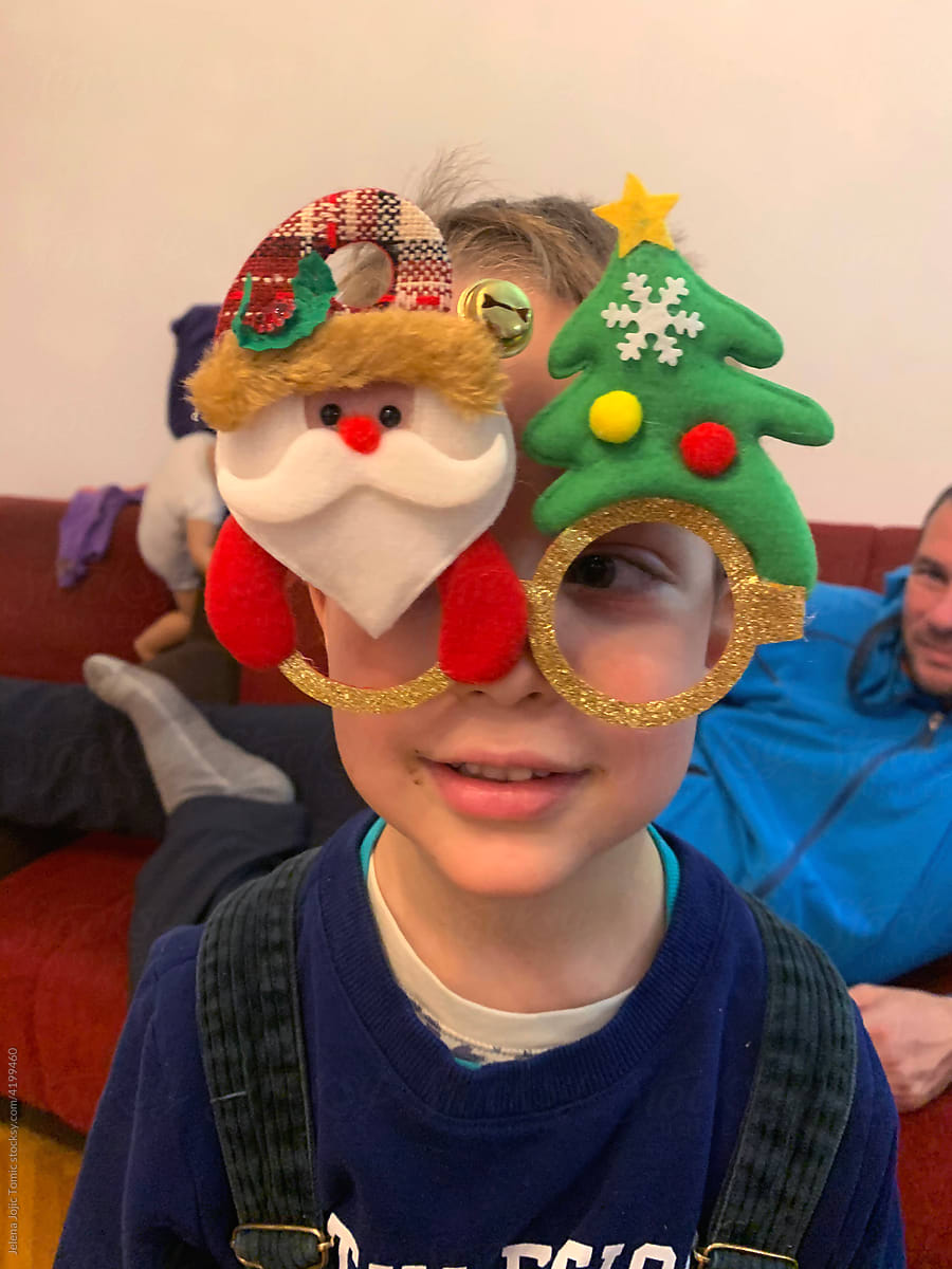 The boy is wearing funny Christmas glasses