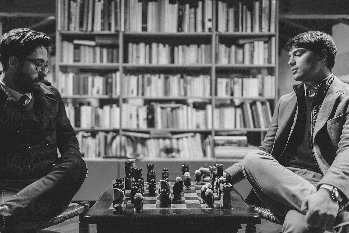 Best Friends Playing Chess into a College Library