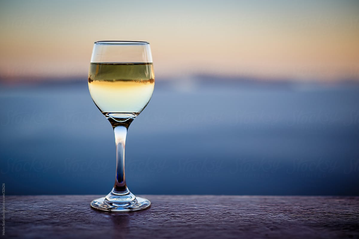 a glass of white wine by the sea