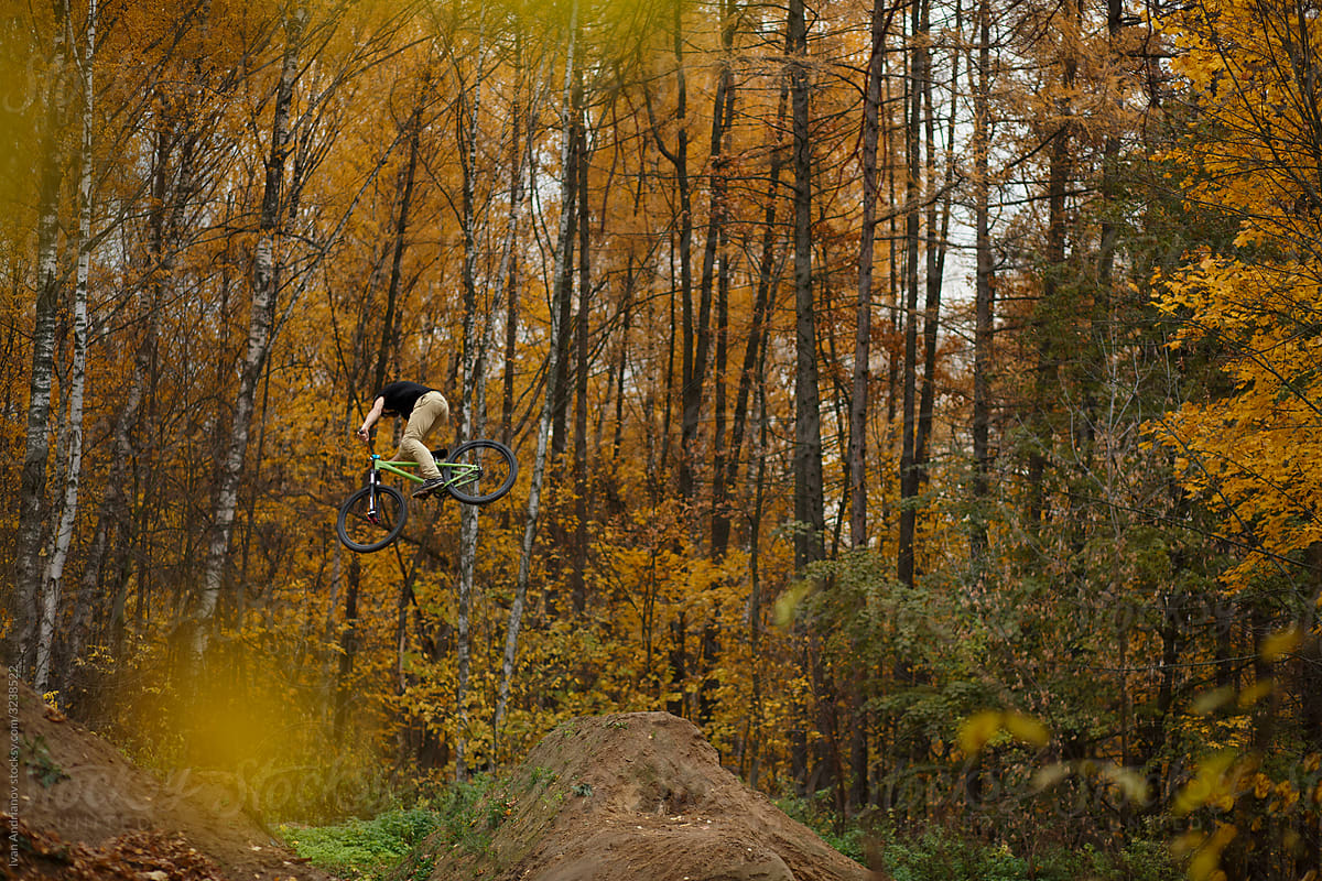 Extreme dirt jump rider on bicycle In Autumn Forest
