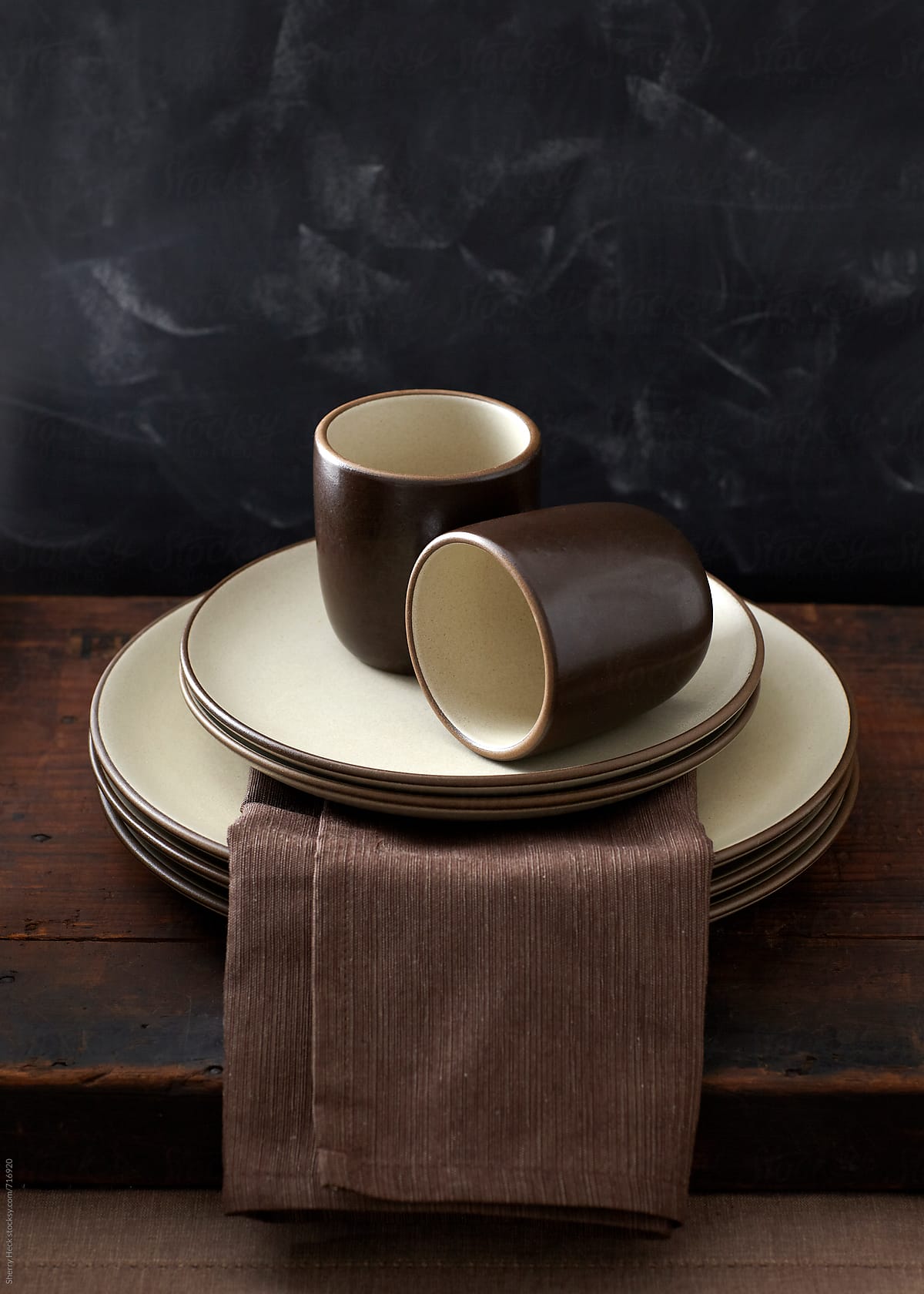 Heathware ceramic plates and cups stacked on wood surface