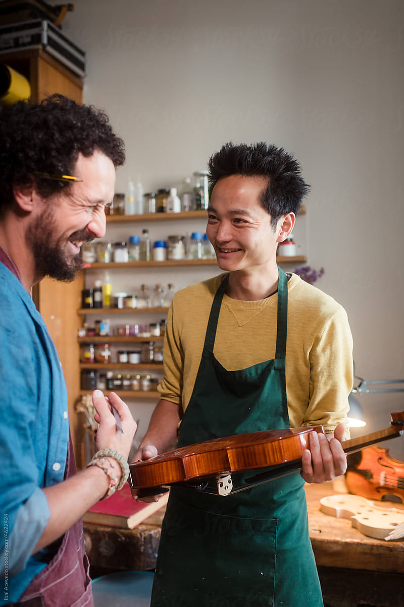 Violin luthiers laughing at workshop