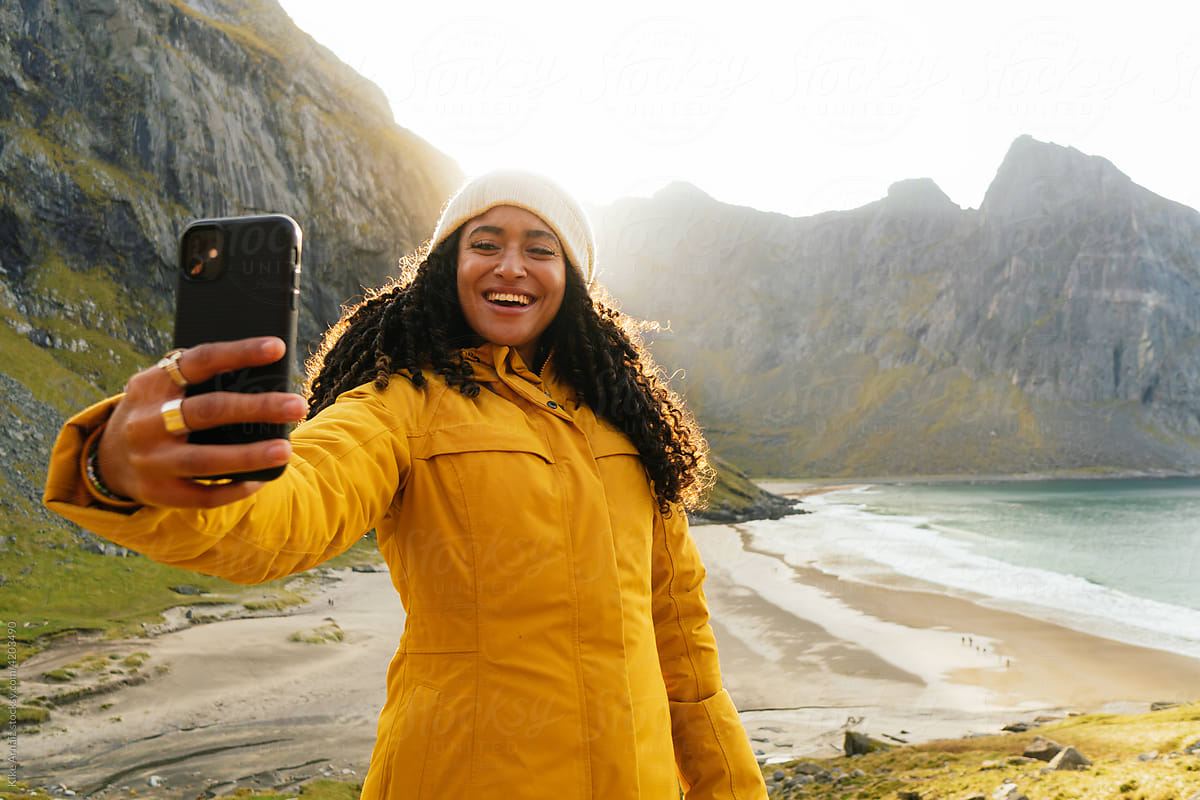 Delighted woman taking selfie on beach