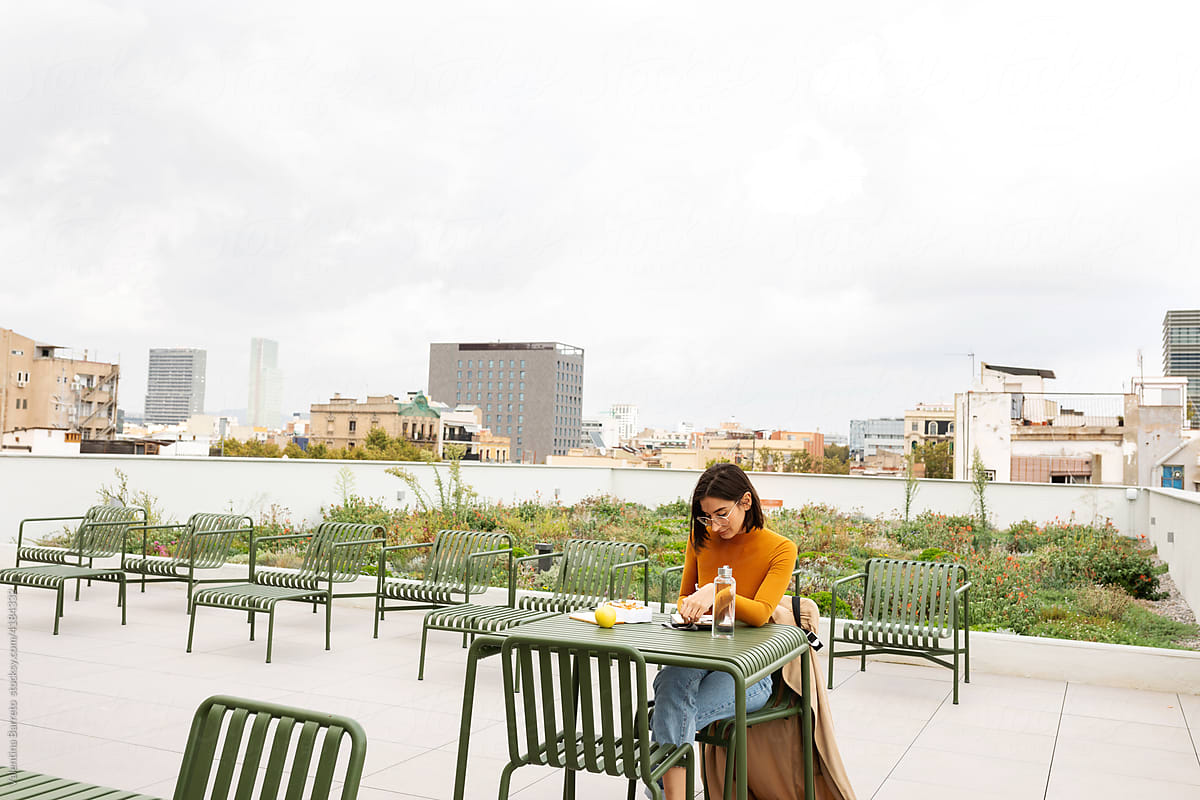 Woman working while having lunch on rooftop