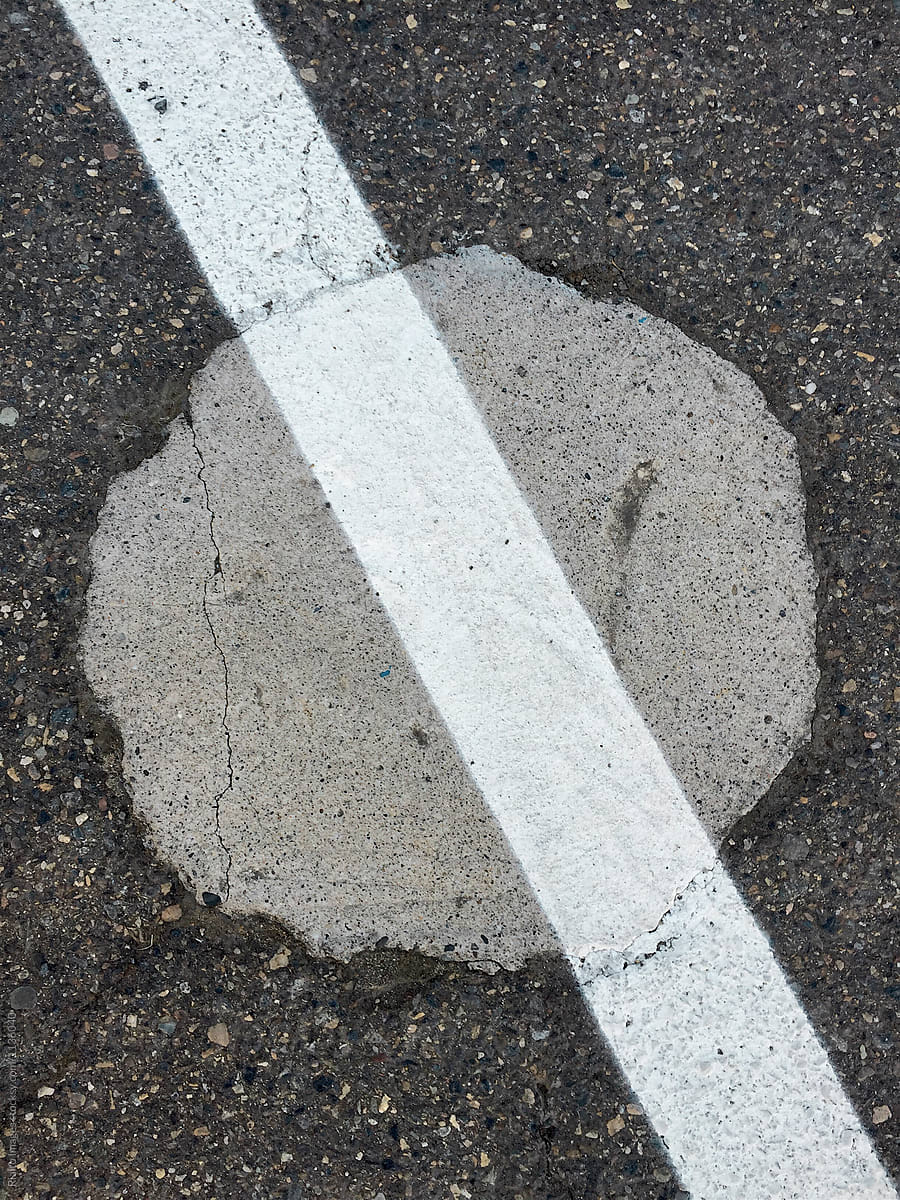 Close up of painted white stripe over asphalt and concrete circle