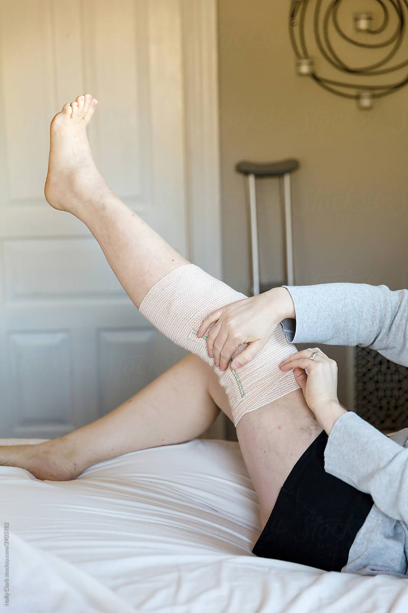 Woman secures bandage on knee