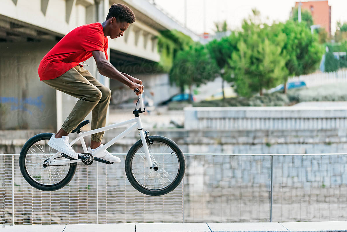 Young african man having fun with bicycle