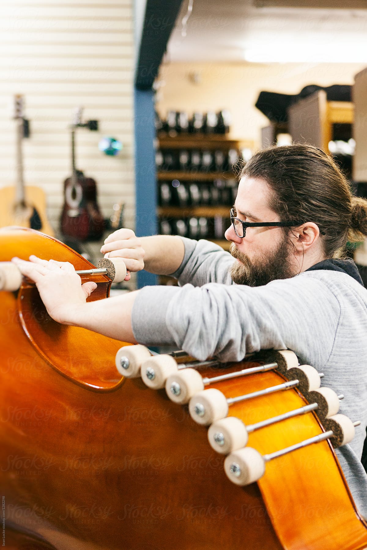 Band: Man Tightening Clamps On Bass Instrument