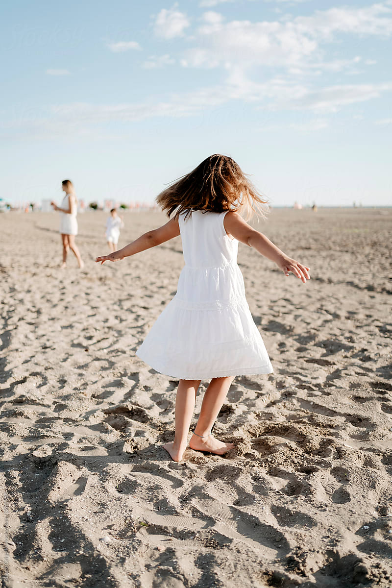 Little girl playing on the beach in summer