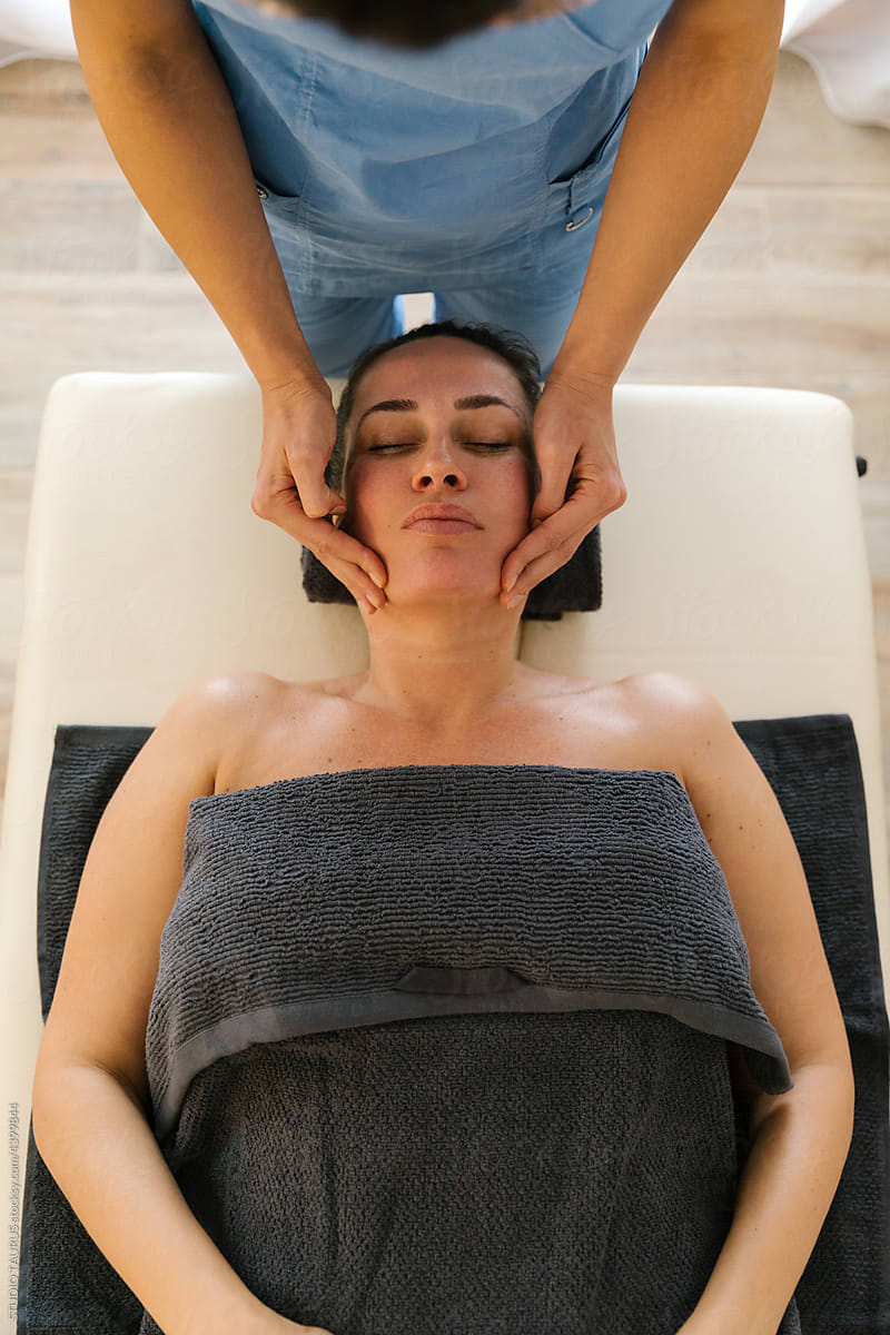 Middle age woman having face massage at spa