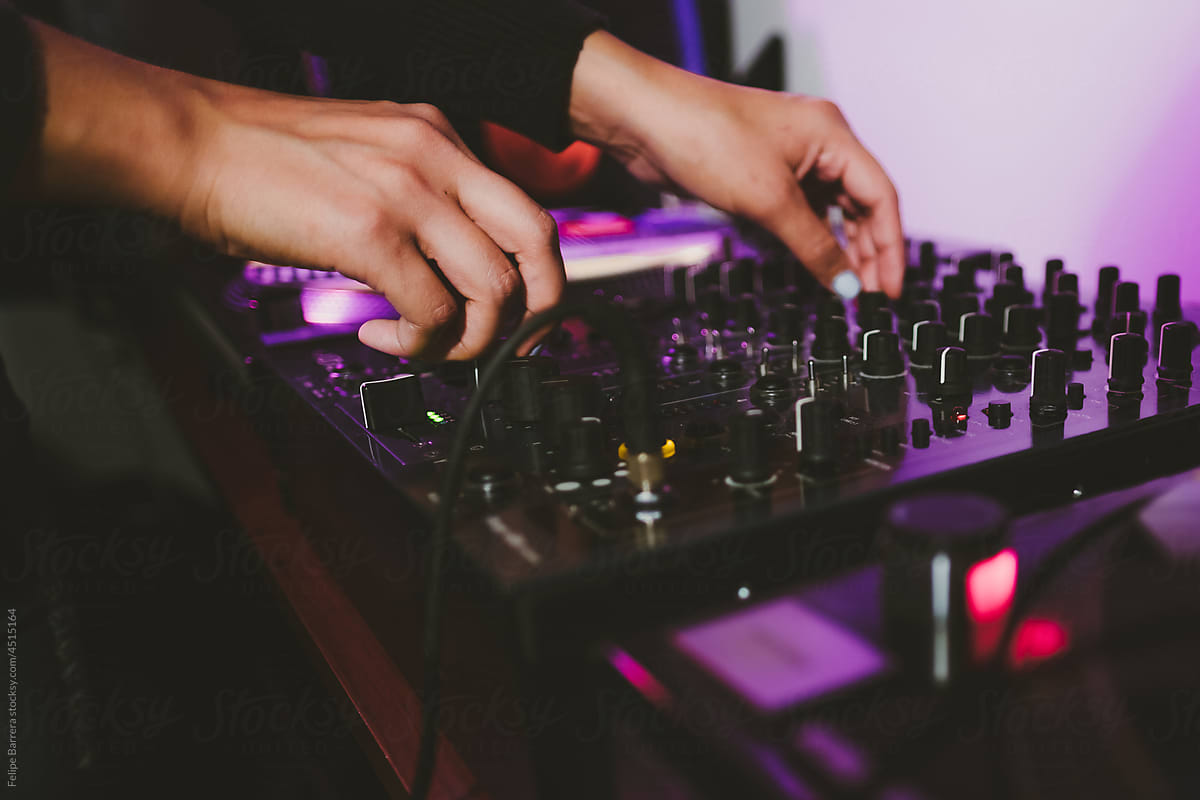 DJ hands controlling a sound mixer