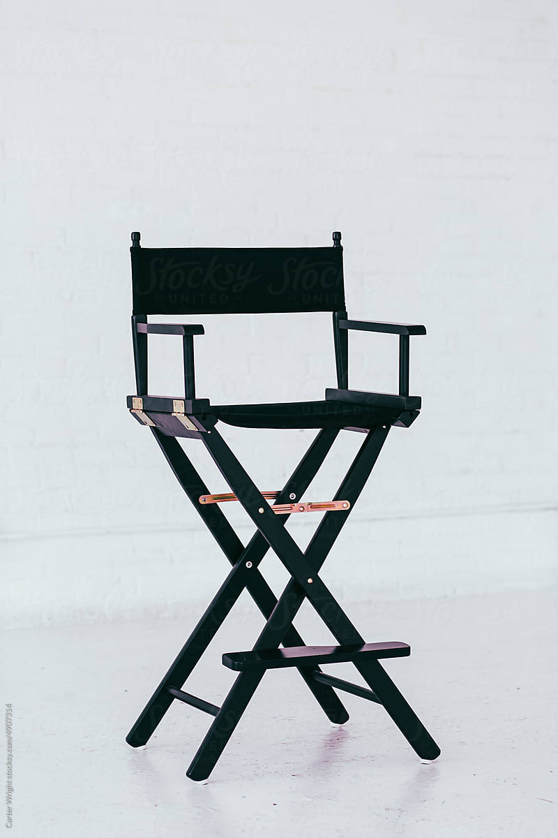 Black director\'s chair in a bright and airy white brick warehouse