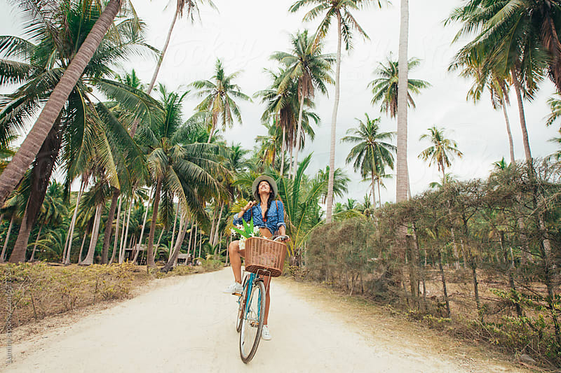 Woman Riding a Bike on a Tropical Island by Lumina - Stocksy United