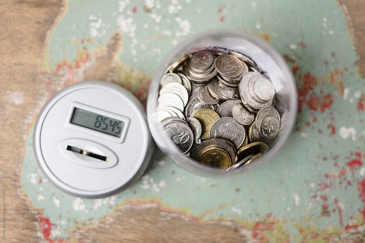 coins in a piggy bank or money jar, with digital lid keeping a tally
