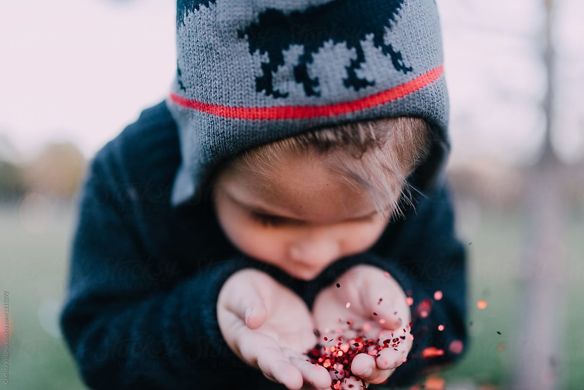 A Young Boy Blowing Christmas Glitter 