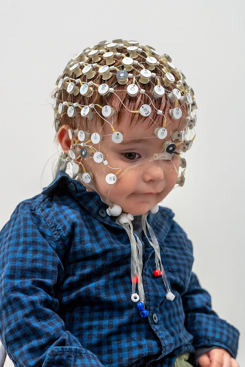Portrait of a toddler in EEG cap in a lab