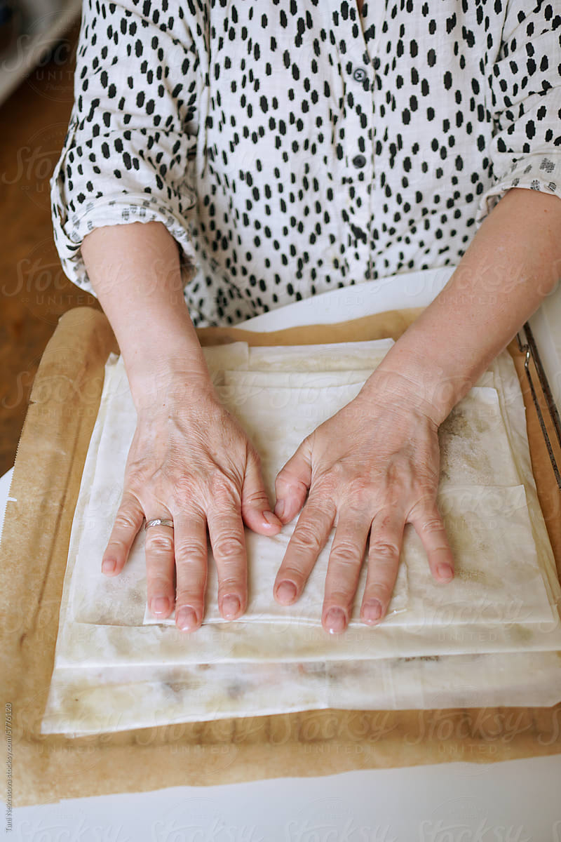 A woman\'s hands cooking a pie in a cozy and bright kitchen at home