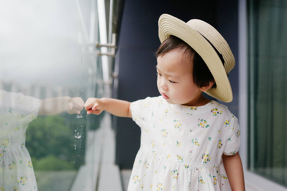 Asian baby playing with bubble machine on the balcony