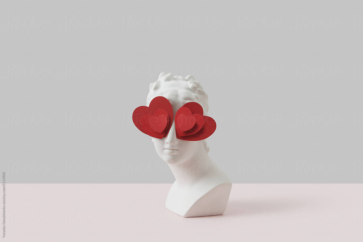 White antique bust with red paper hearts eyes.