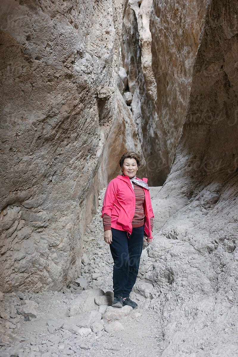 woman stands in the midst of a canyon landscape