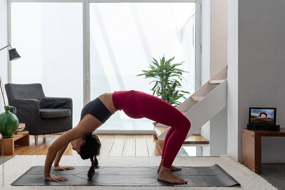 Woman practicing Wheel Pose at home