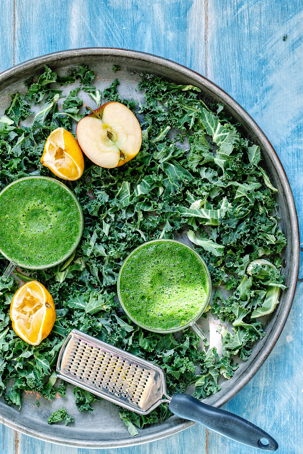 Kale smoothies on tray with ingredients.