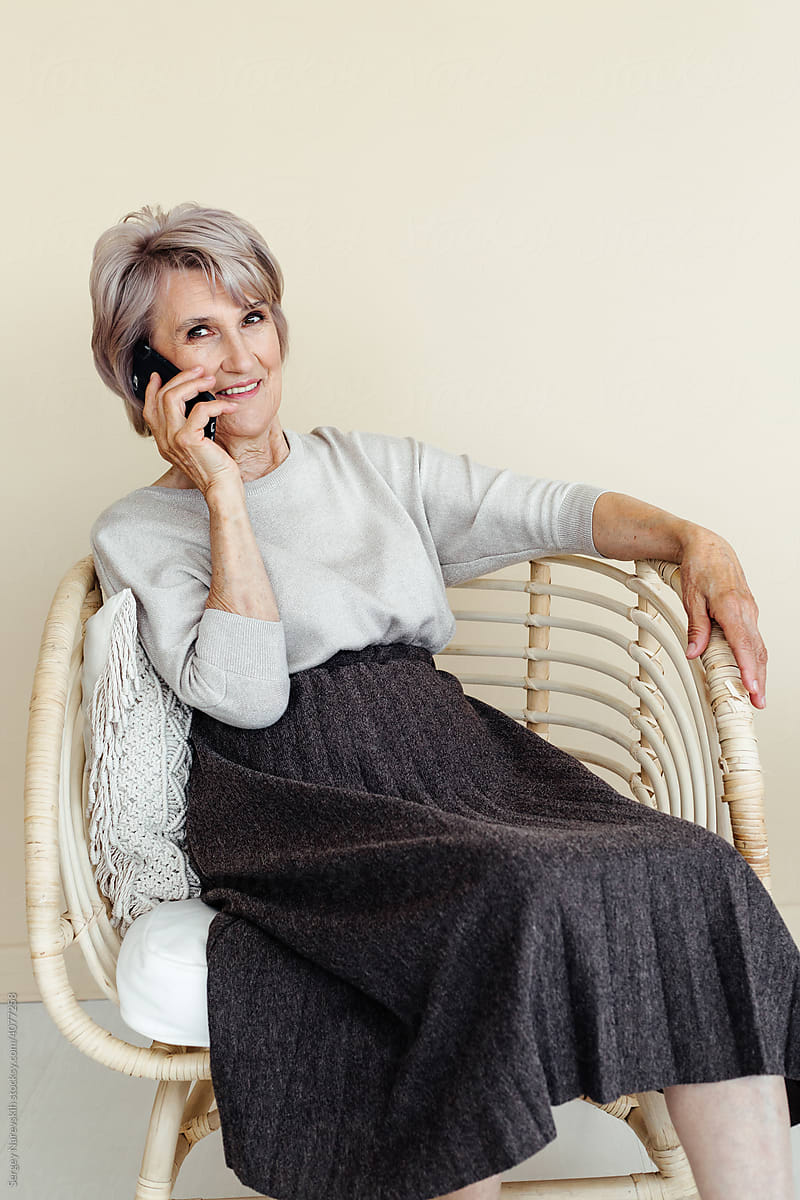 Joyed aged woman speaking on phone